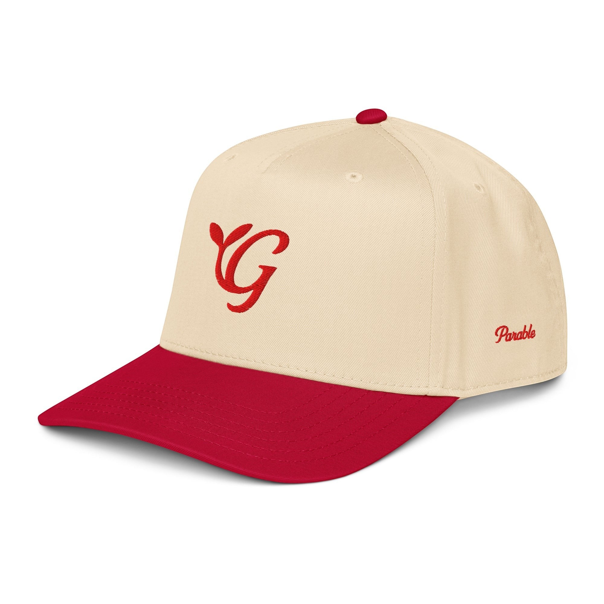 Parable Golf red letter G embroidered on a cream 65% polyester, 35% cotton baseball hat with a red brim and snapback closure.